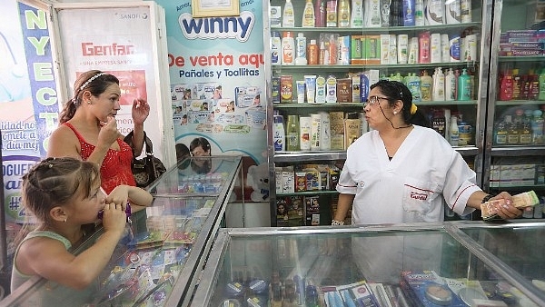 A Venezuelan woman (L) waits to purchase items from a pharmacy (Mario Tama/Getty Images)