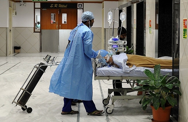 Hospital staff shift a patient at the Narayana Hrudayalaya cardiac-care hospital in Bengaluru. (Manjunath Kiran/AFP/Getty Images)