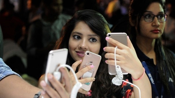 A woman takes a selfie on a smartphone. (Burhaan Kinu/Hindustan Times via Getty Images)