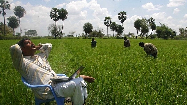 An agriculturist sits with his laptop in Kadiramangalam, a small village in the Kaveri Delta. (Satish Bate/Hindustan Times via GettyImages)