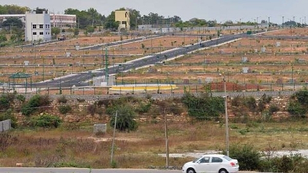 A car drives in front of residential plots on the outskirts of Bengaluru in December 2016. (MANJUNATH KIRAN/AFP/GettyImages)