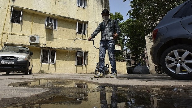 South Delhi Municipal Corporation worker sprays mosquito repellent at a house in Lajpat Nagar II during an anti-dengue drive in New Delhi. (Raj K Raj/Hindustan Times via Getty Images)