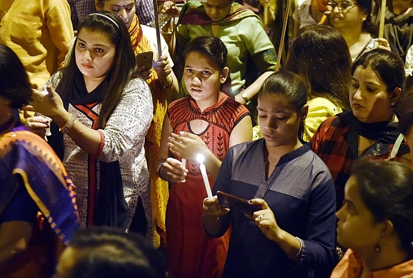 Delhi BJP youth wing observes a candle-light march protesting rape of the minor.