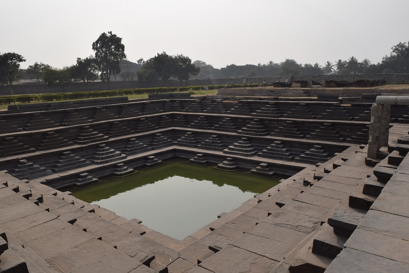 Pushkarin or water tank in Hampi, Karnataka. Such structures were commonly built during the great Vijayanagara Empire (fourteenth century), and were typically located within temple complexes. The massive water tanks have large stone steps that allowed people to get into the water easily. The water tanks are connected to an extensive network of stone aqueducts and canals, which in turn drew water from the nearby Tungabhadra river. <i>Picture clicked on 24 December 2016 by the author.</i>