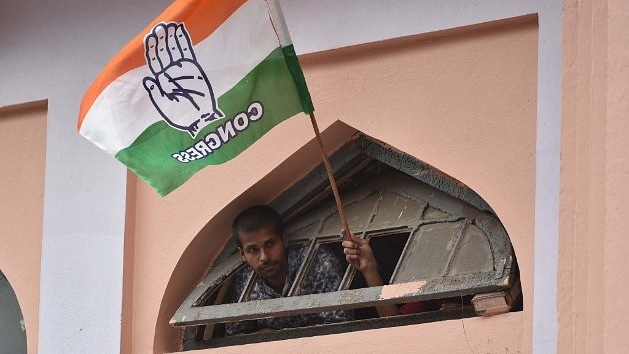 A Congress supporter waves the party flag during the road show of the All India Congress Committee president Rahul Gandhi in Bengaluru. (Arijit Sen/Hindustan Times via Getty Images)