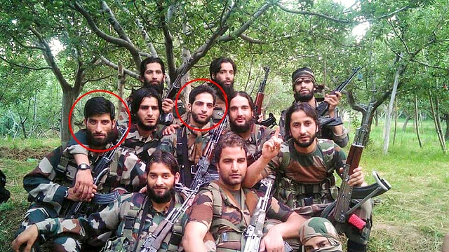 Photograph showing  terrorists donning army fatigues and holding firearms. 