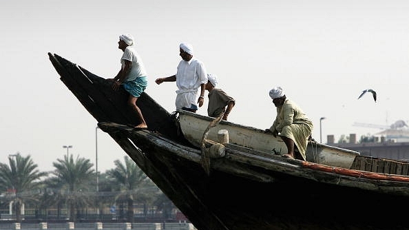 An Indian dhow crew straddles the bow of their boat December 14, 2005, in Dubai, United Arab Emirates. (Chris Jackson/Getty Images)