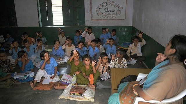 Indian school children read in a classroom at a government school in Bagpath district in Uttar Pradesh. (SAJJAD HUSSAIN/AFP/Getty Images)