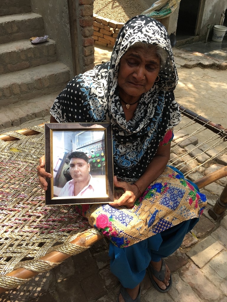 A teary-eyed Lajjawati holds a portrait of her son Devendra, who died in August