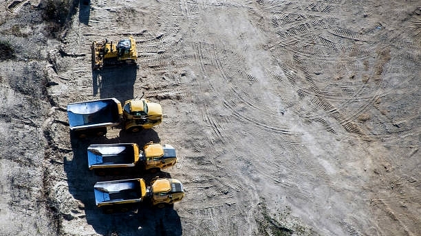 Dump trucks sit at an aggregate mine processing facility. (James MacDonald/Bloomberg via Getty Images)