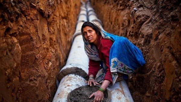 An Indian woman works at a construction project in front of the Jawaharlal Nehru Stadium in New Delhi. (Daniel Berehulak/Getty Images)