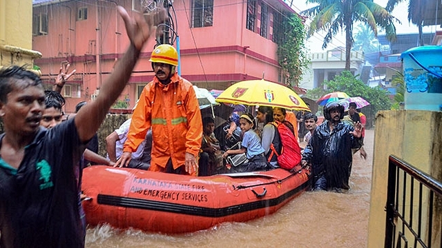 Rescuers shift people to a safer place from a flooded locality in Mangaluru.