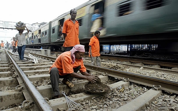 Indian railway workers perform track maintenance at a station in Kolkata. (DESHAKALYAN CHOWDHURY/AFP/Getty Images)