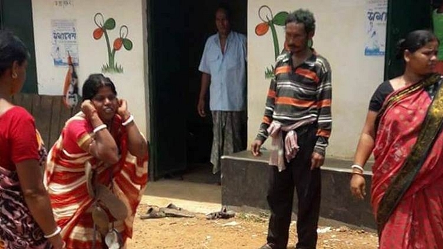  A woman with a garland of shoes around her neck and squatting holding her ears in front of TMC office (Twitter/@me_sourish).