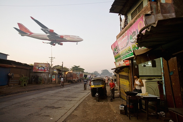 An Air India plane flies over Jari Mari in Mumbai prior to landing at the Chhatrapati Shivaji International Airport (Daniel Berehulak/Getty Images)