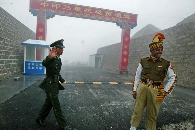 Indian and Chinese soldiers at a border crossing. (Diptendu Dutta/GettyImage)