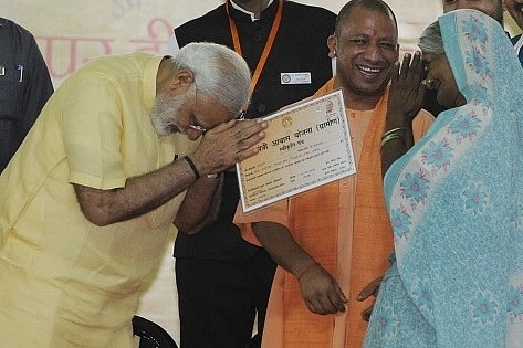 Prime Minister Narendra Modi distributing certificate of Prime Minister Awas Yojana. (Deepak Gupta/Hindustan Times via Getty Images)