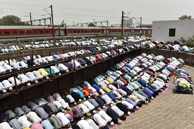 Devotees take part in the afternoon prayers  at the railway yard of the New Delhi Railway Station. (Sanchit Khanna/Hindustan Times via Getty Images)