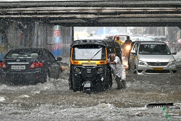 A man pushes his vehicle as it rains at Andheri Subway in Mumbai. (Shashi S Kashyap/Hindustan Times via Getty Images)