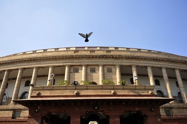 A pigeon flies over the Parliament building during the winter session in December 2015 in New Delhi. (Vipin Kumar/Hindustan Times via Getty Images)