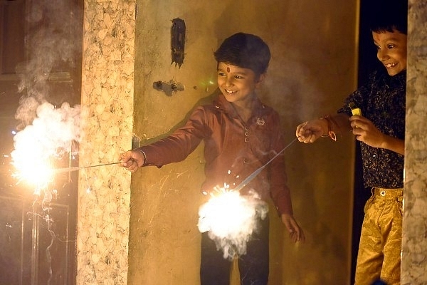 Children play with firecrackers while celebrating Diwali, the annual festival of lights, in New Delhi, India. (Sonu Mehta/Hindustan Times via Getty Images)