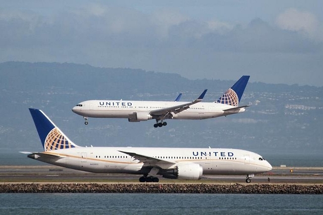 
A United Airlines Boeing 787 taxis as a United Airlines Boeing 767 lands.

