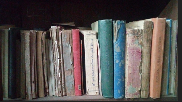 Books shabbily arranged after decades of neglect. 