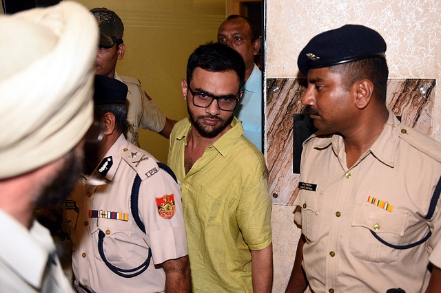 Delhi police officials with JNU student Umar Khalid. (Sonu Mehta/Hindustan Times via Getty Images)