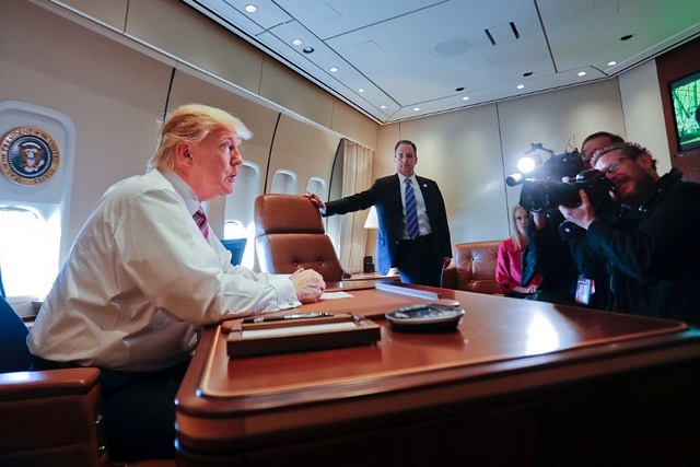 President Donald Trump sits at his desk on Air Force One.