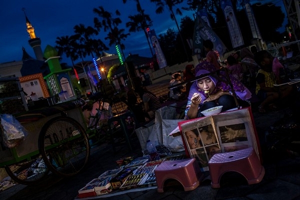 Muslim woman eating in Indonesia (Ulet Ifansasti/Getty Images)