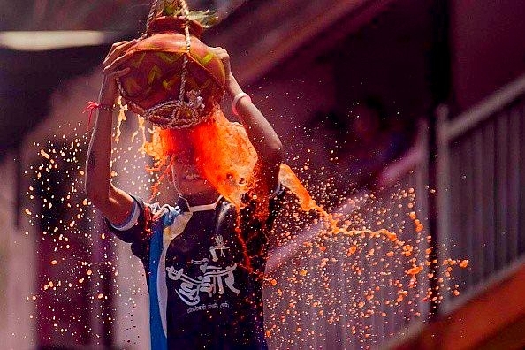 A young <i>govinda </i>breaks the <i>handi</i>. (Kunal Patil/Hindustan Times via GettyImages)