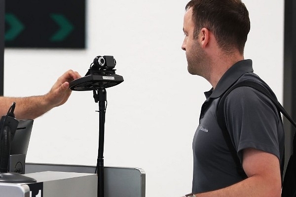 A U S Customs officer instructs a traveller to look into a camera as he uses facial recognition technology on 27 February 2018 at Miami International Airport.  (Photo by Joe Raedle/Getty Images)