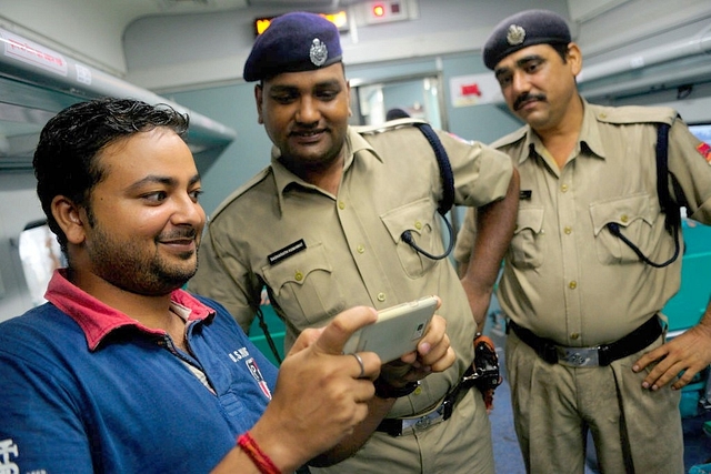 A passenger uses his phone on an Indian train. (Pradeep Gaur/Mint via Getty Images)