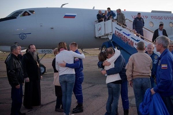 Expedition 57 Flight Engineer Alexey Ovchinin of Roscosmos (left) and Flight Engineer Nick Hague of NASA (right) embrace their families after landing at the Krayniy Airport. (NASA/Bill Ingalls)