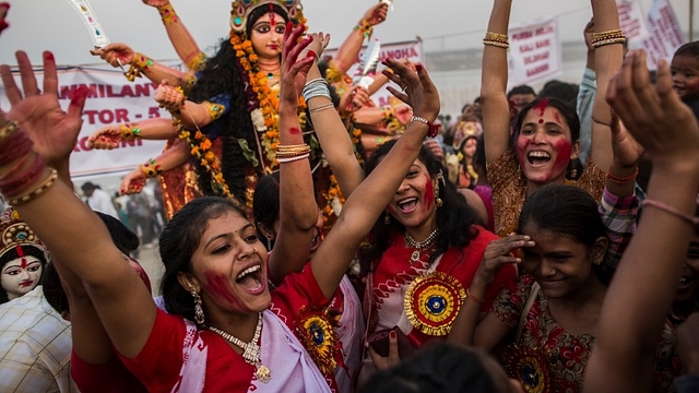 Hindu devotees chant prior to immersing an idol of Goddess Durga into the Yamuna river on the last day of the Durga Puja. (Daniel Berehulak/Getty Images)