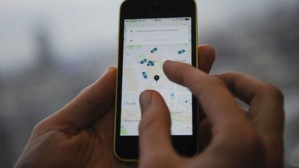 

A man  holding a smartphone showing the App for ride-sharing cab service Uber. (DANIEL SORABJI/AFP/Getty Images)