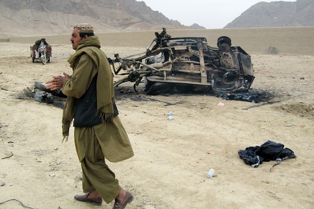 Afghans stand at the site of a blast on February 27, 2011 in Arghandab district of Kandahar province, Afghanistan (Photo by Getty Images)