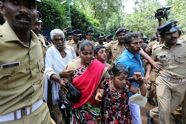 Police escort a woman during the protests at Sabarimala  (Photo by Vivek Nair/Hindustan Times via Getty Images)