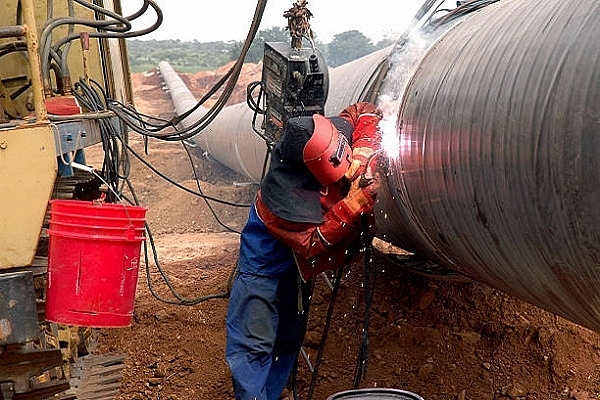 Engineers weld carbon steel pipes as part of a gas pipeline. (NOAH SEELAM/AFP/Getty Images)