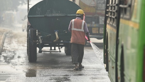 A worker sprinkles water roadside in a bid to bring down pollution from dust near Pragati Maidan on October 30, 2018 in New Delhi, India. (representative image) (Raj K Raj/Hindustan Times via Getty Images)