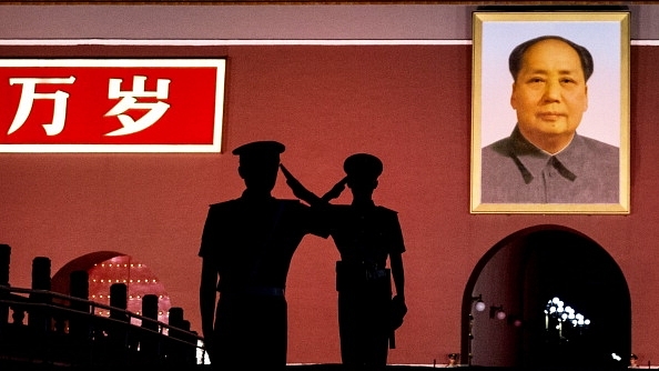 Chinese soldiers salute near Mao’s portrait in 2014 (Kevin Frayer/Getty Images)