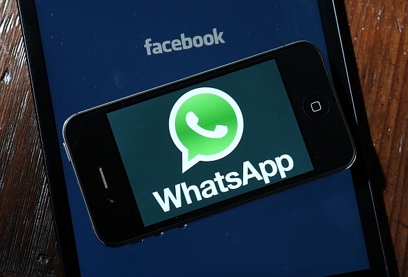 A phone displaying a WhatsApp logo over another device’s Facebook logo. (representative image) (Photo Illustration by Justin Sullivan/Getty Images)