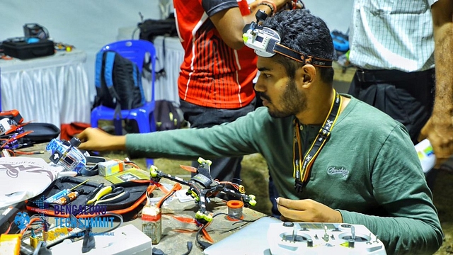 Drone racers fine-tune their mean machines to compete in the night drone race happening in Bengaluru. (Image courtesy of twitter.com/blrtechsummit)&nbsp;