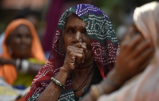 An elderly woman smokes bidi during a rally at Jantar Mantar, on October 1, 2018 in New Delhi. (Photo by Biplov Bhuyan/Hindustan Times via Getty Images)