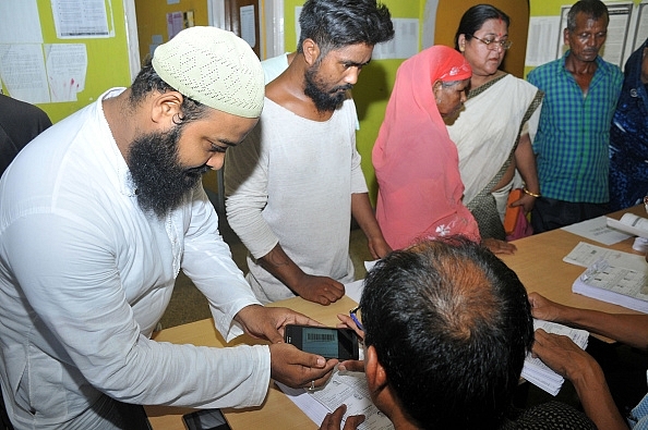 People checking their names in the draft NRC at an NRC Seva Kendra. (Photo by Rajib Jyoti Sarma/Hindustan Times via Getty Images)