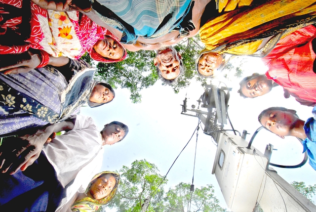 Villagers are standing around a poll eagerly waiting for the flow of electricity in village Garanayarchhara (Indranil Bhoumik/Mint via Getty Images)&nbsp;