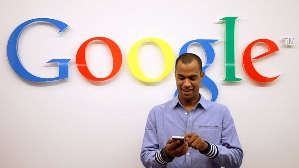 A man using a smartphone in front of the Google logo at the company’s offices in Berlin (Representative image) (Adam Berry/Getty Images)