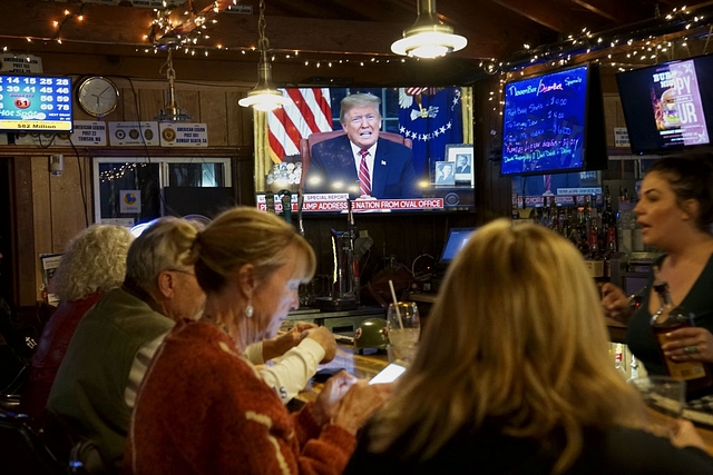 Members of American Legion Post 416 watch President Donald Trump speak on January 8, 2019 in Encinitas, California. (Sandy Huffaker/Getty Images)