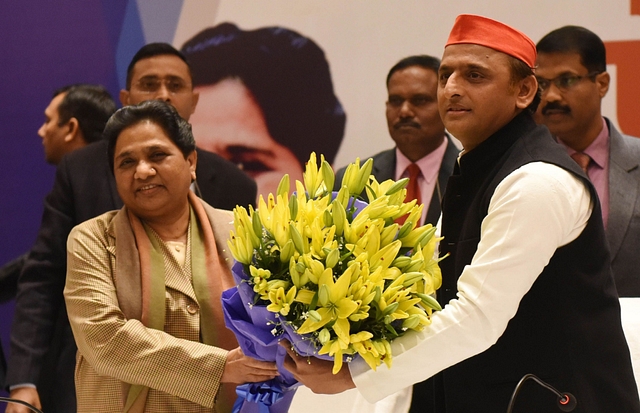 Samajwadi Party president Akhilesh Yadav presents a bouquet to Bahujan Samaj Party chief Mayawati during a joint press conference in Lucknow. (Subhankar Chakraborty/Hindustan Times via GettyImages)&nbsp;