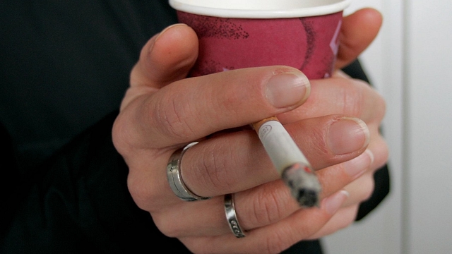 A smoker enjoys a cigarette and a coffee outside an office building (Ralph Orlowski/Getty Images)